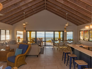 A Dream Come True Villa&rsquo;s bright and modern main room with a lofted ceiling and open kitchen, dining and living areas.