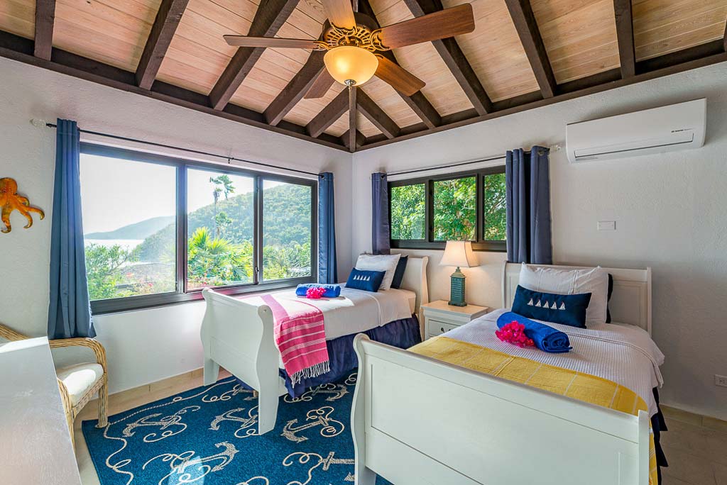 Double bedroom at Euphoria villa with twin beds, a ceiling fan and windows looking out on Leverick Bay, Virgin Gorda.