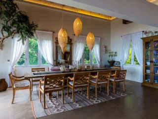 La Vida Villa: Dining Room Formal dining area in La Vida Villa with modern hanging lights, smooth stone flooring and a cabinet containing tableware.