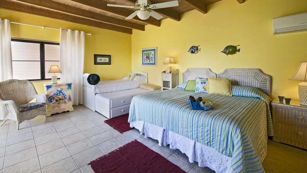 Bright double-twin guest room at Adagio Villa with an extra trendle bed and single mattress, tile floors and ceiling fan.