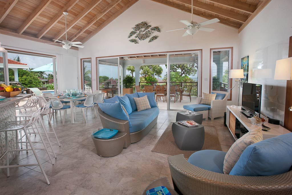 Bright main room at Blue Lagoon Villa with cool tile floors, a lofted wood ceiling and spacious sitting and dining areas.
