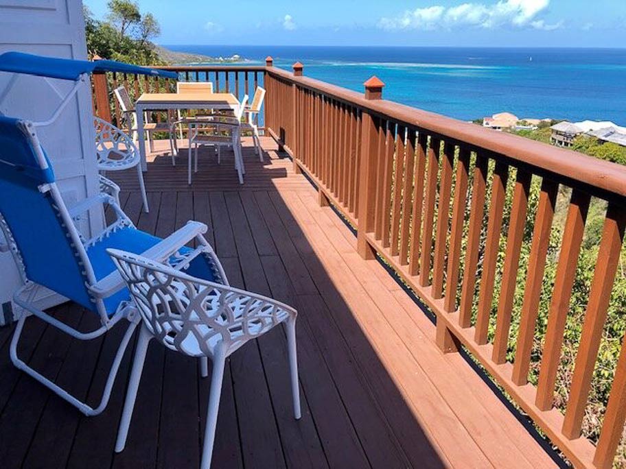 Wooden deck for sitting in the sun and dining alfresco overlooking the calm blue waters of Leverick Bay, Virgin Gorda.
