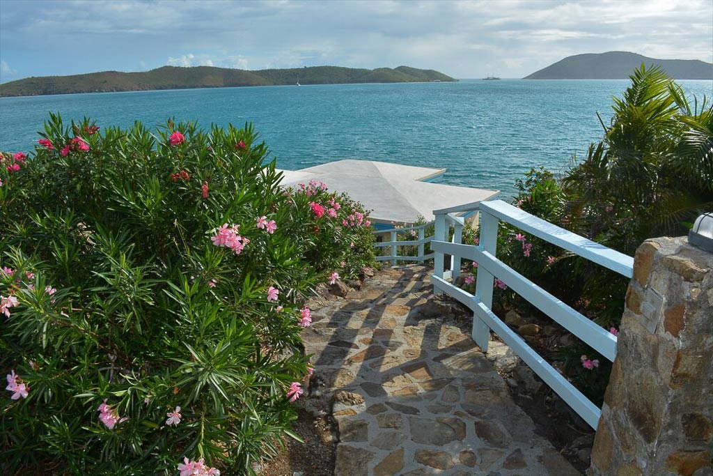A natural stone path amid a lush tropical garden leading down to Serendipity Villa and beautiful Leverick Bay beach.