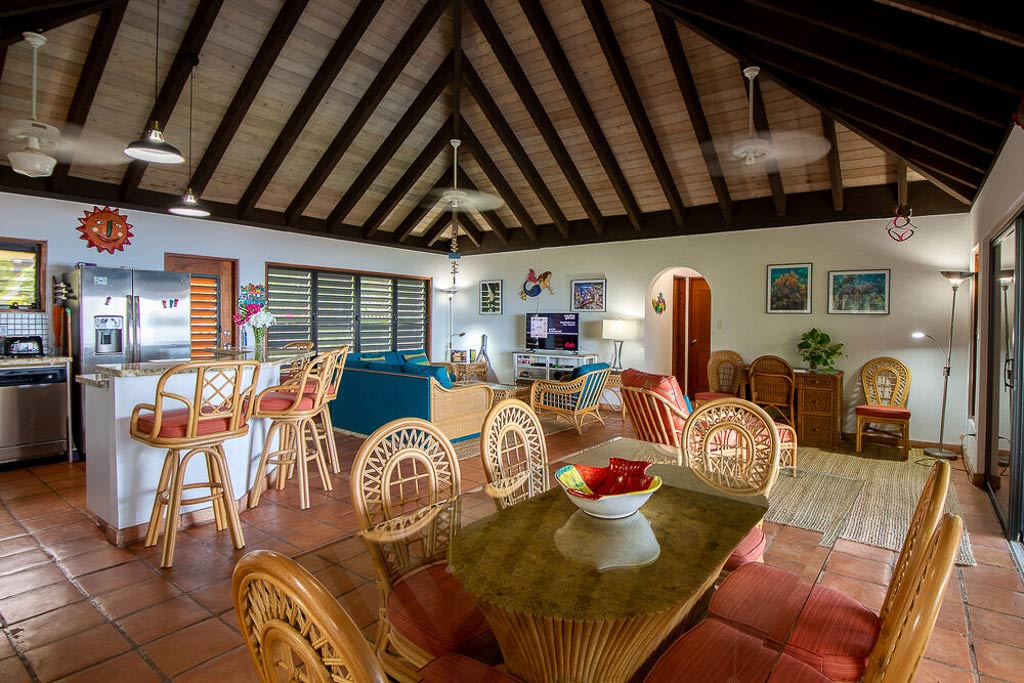 Villa Del Sole main room with tile floors, a vaulted wood ceiling with fans and a separate kitchen, dining and living areas.