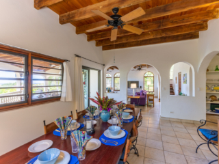 Bellamare Villa: Dining Room Formal dining area at Bellamare Villa with natural light coming through a window and separate living space in the background.