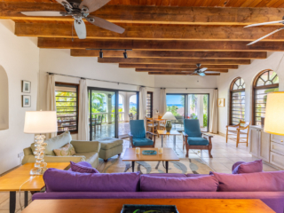Bellamare Villa: Main Room Bright, modern main room at Bellamare Villa with white walls, colorful furnishings and a wood-beam ceiling with ceiling fans.