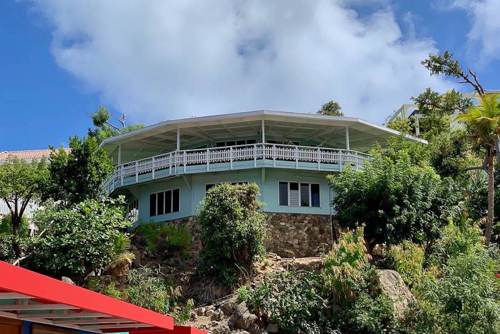 The marine blue and natural stone façade at Vista Villa on the lush green hillside at Leverick Bay, Virgin Gorda.