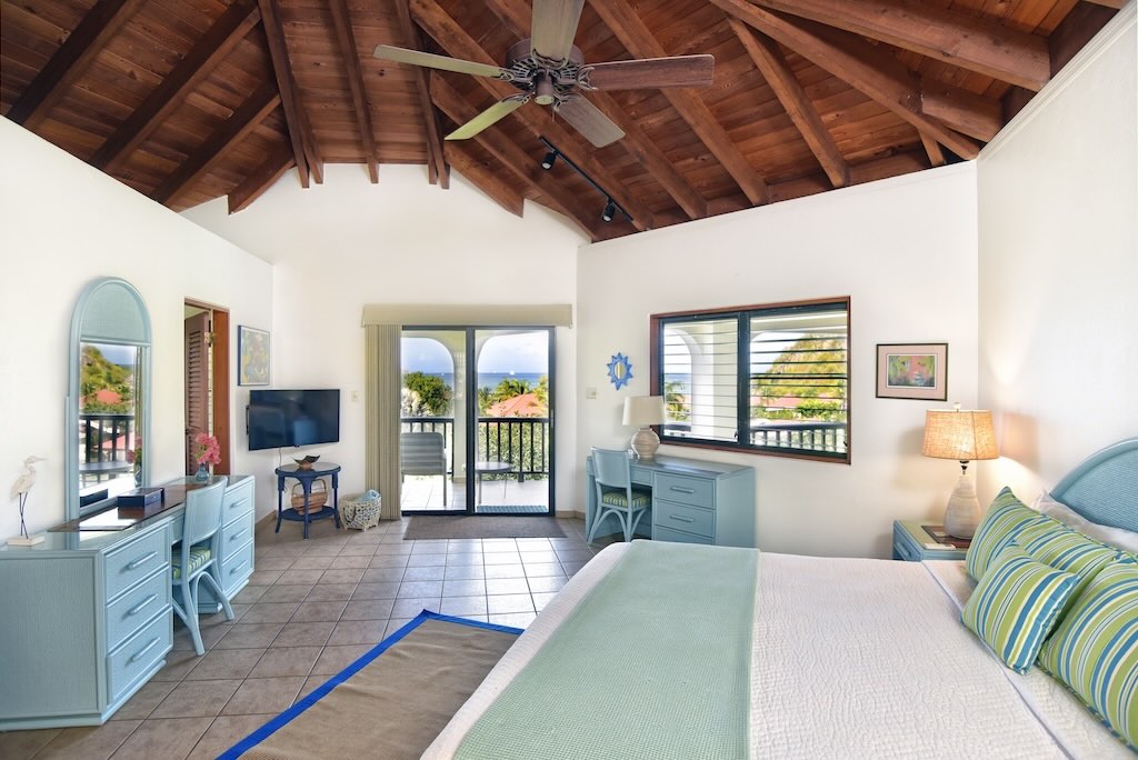 Loblolly Bedroom Spacious master bedroom at Loblolly Villa with a king bed, desk and chair, high ceiling and a door open to the private patio.
